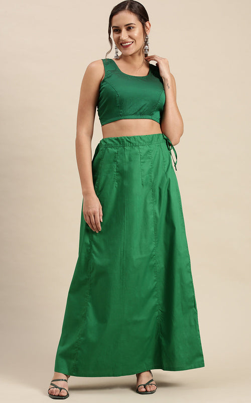 Woman wearing a green petticoat inskirt on a beige background