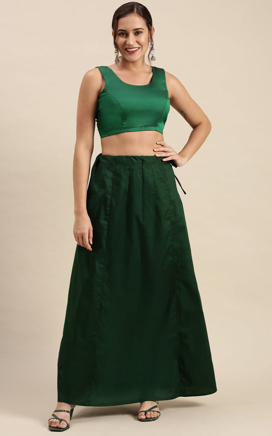 Woman wearing a green traditional outfit  with petticoat inskirt on a beige background