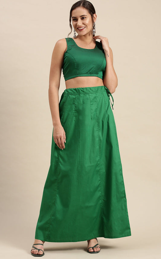 Woman wearing a green petticoat inskirt on a beige background