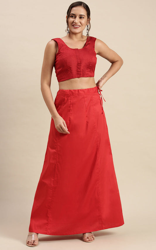 Woman wearing a red outfit  and petticoat inskirt on a beige background