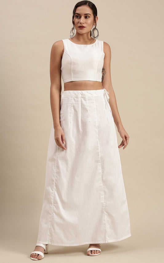 Woman wearing a white outfit with petticoat inskirt on a beige background