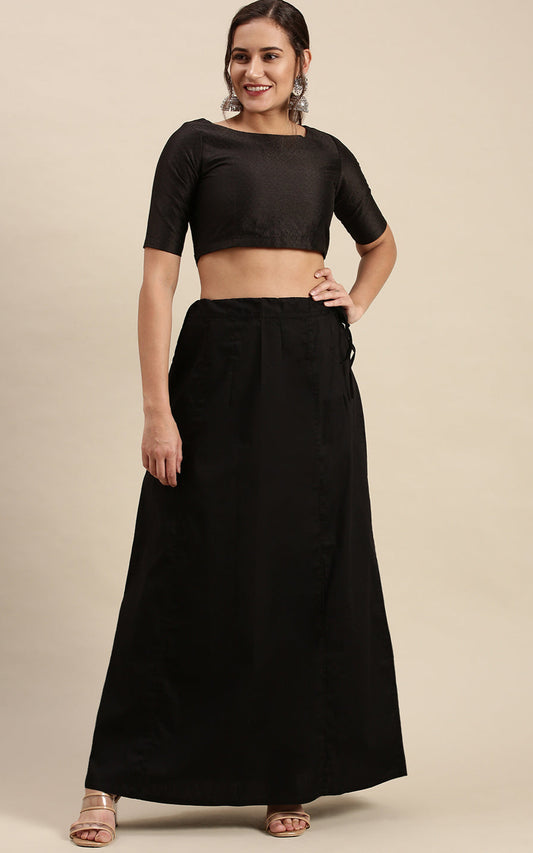 Woman wearing a black outfit  with petticoat inskirt on a beige background